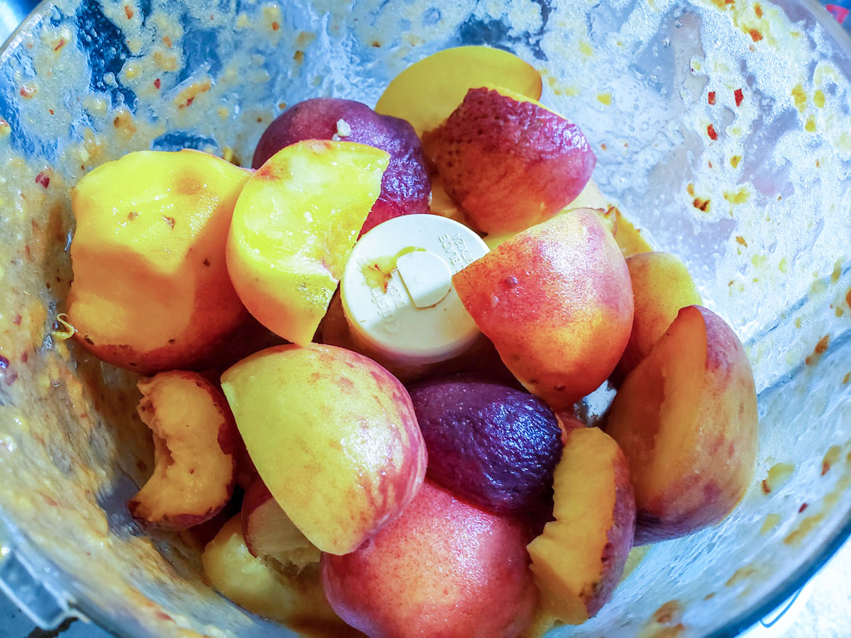 Peach pieces in a food processor bowl.