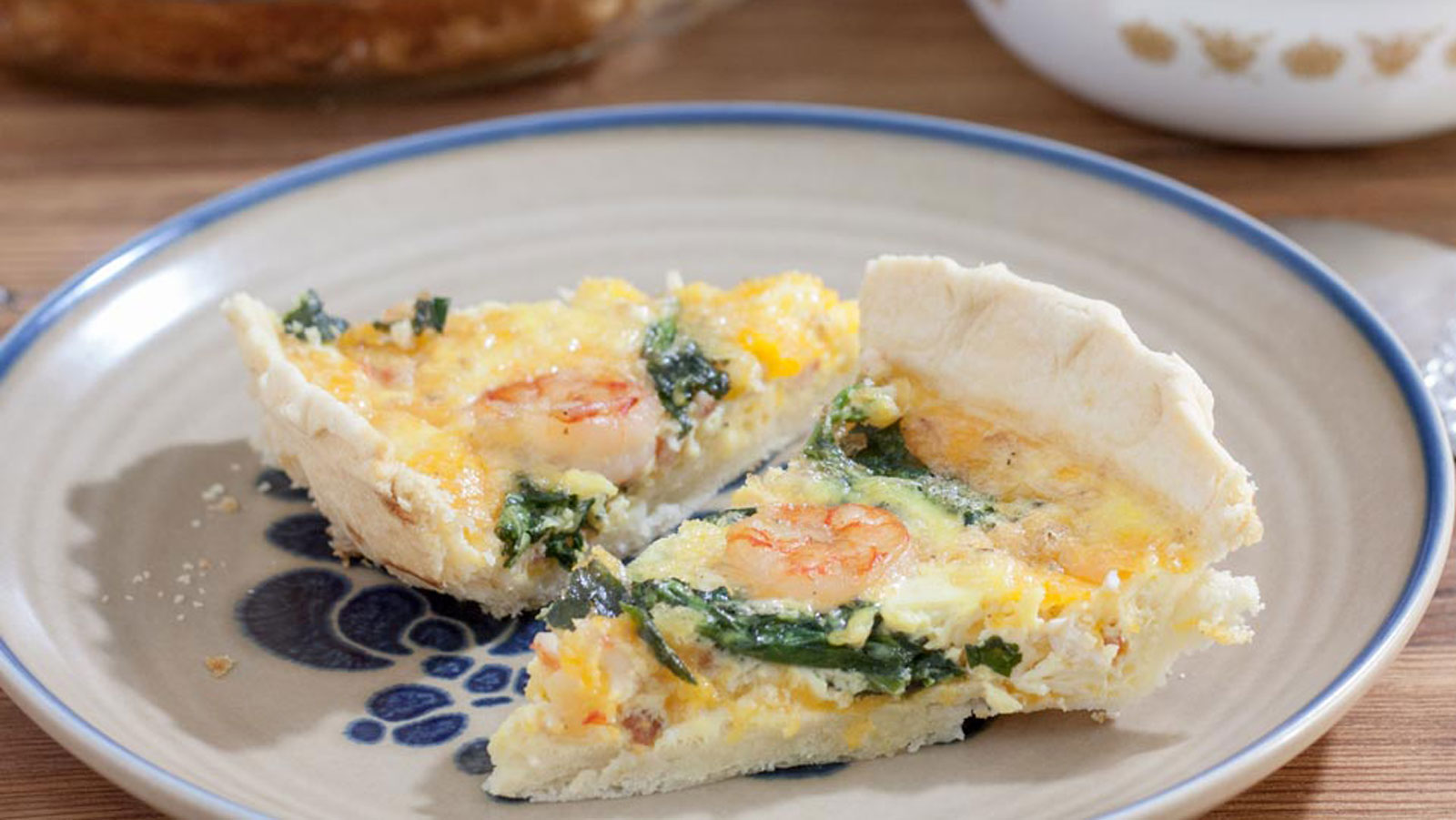 Two slices of shrimp quiche on beige plate.