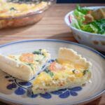 Two slices of quiche with visible shrimp and chopped asparagus.