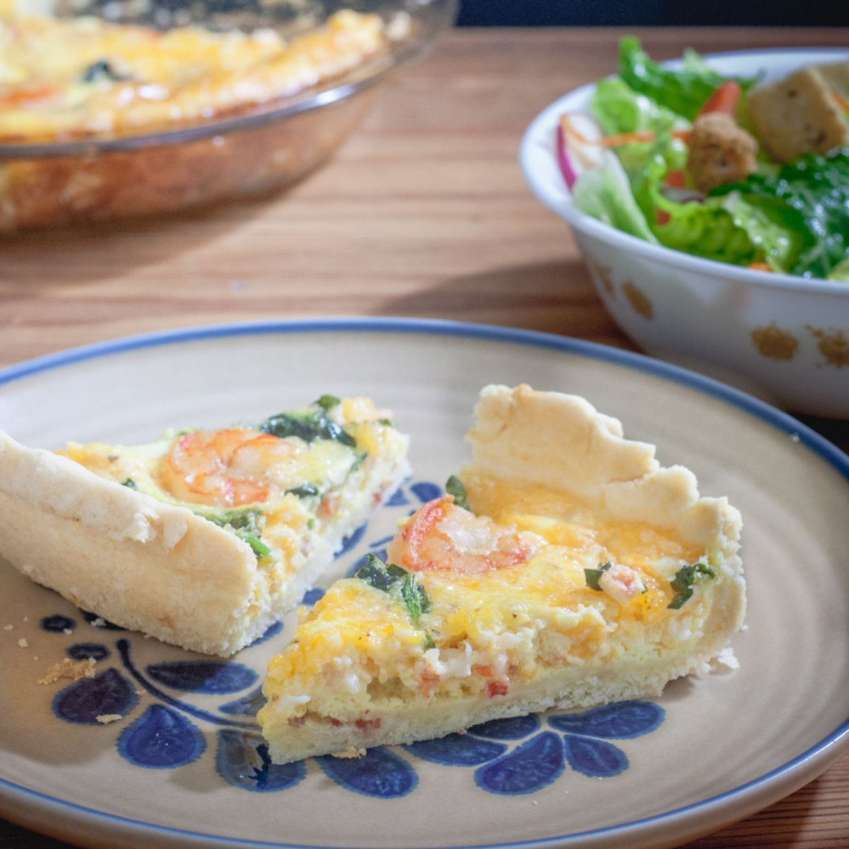 Two slices of quiche with visible shrimp and chopped asparagus.