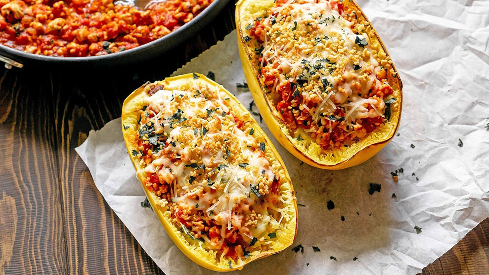 Two stuffed spaghetti squash on a white towel.