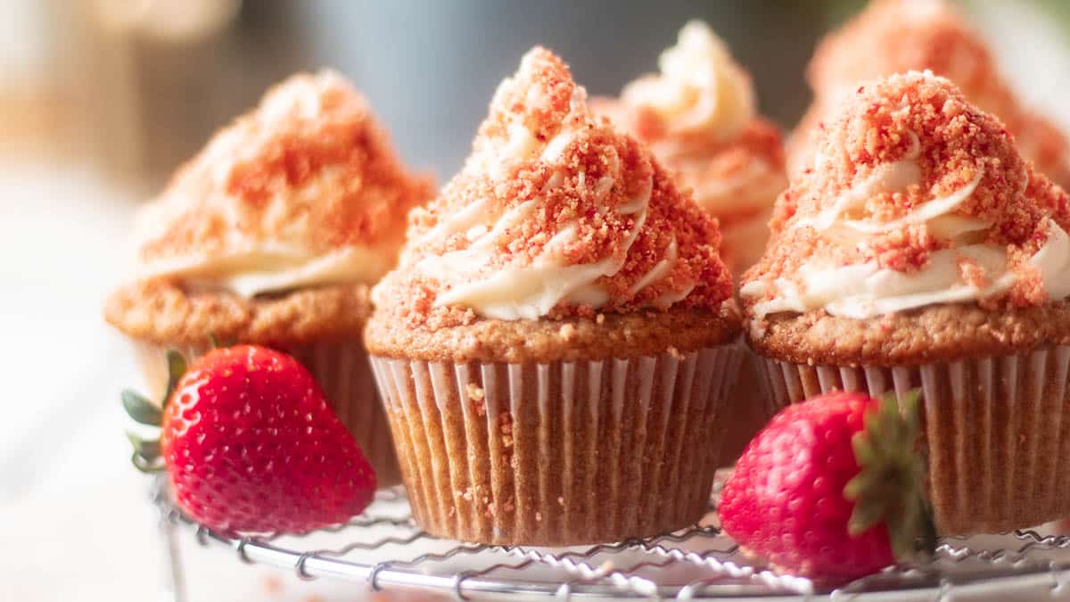 Pink cupcakes on a cooling rack.