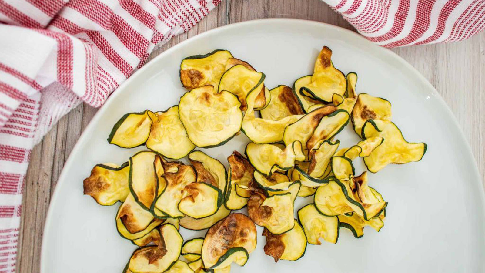 White plate with zucchini chips spread over it.