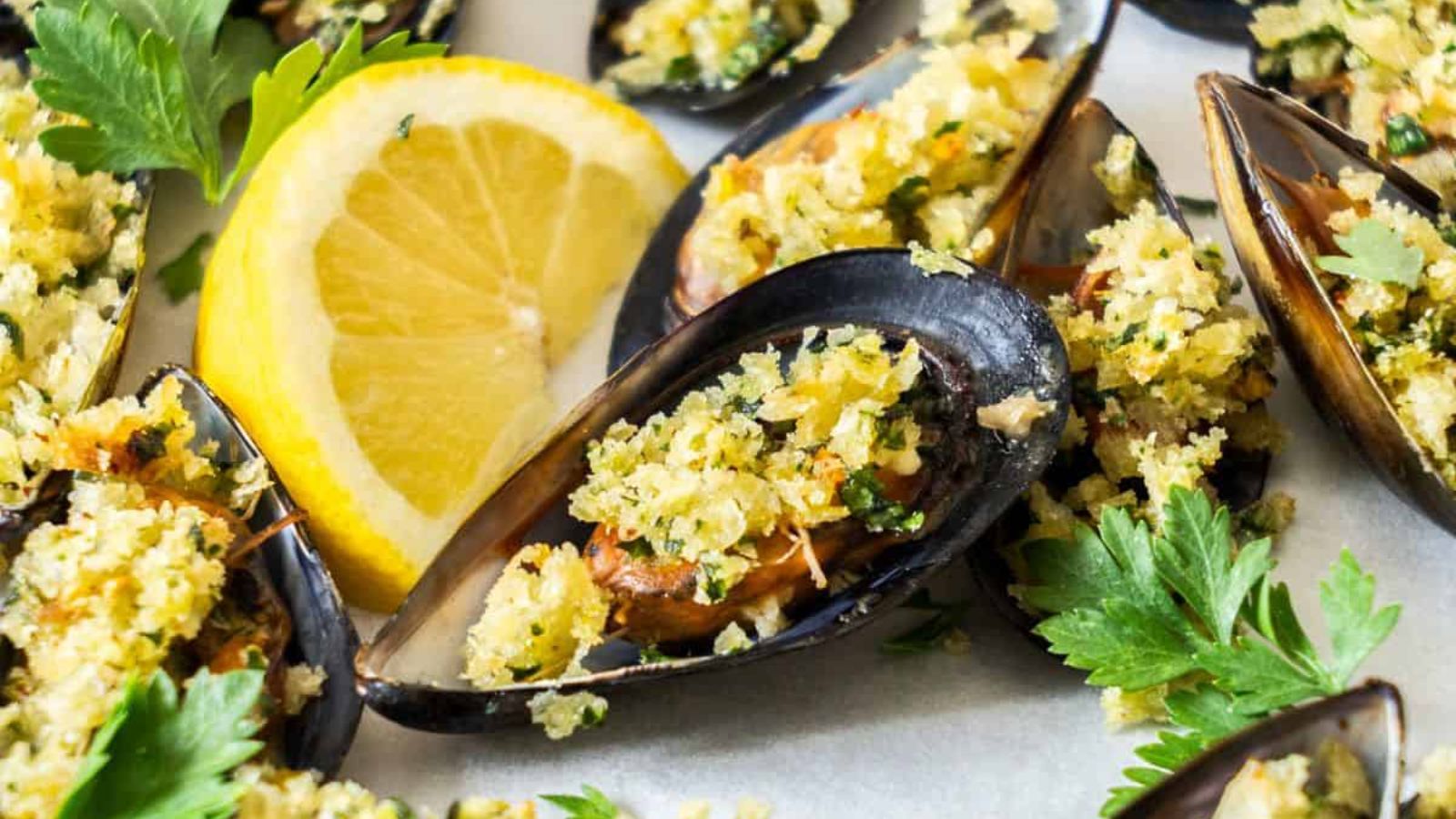 Baked stuffed mussels with sliced lemon.