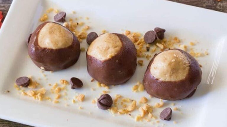 Chocolate covered peanut butter balls on a white plate.