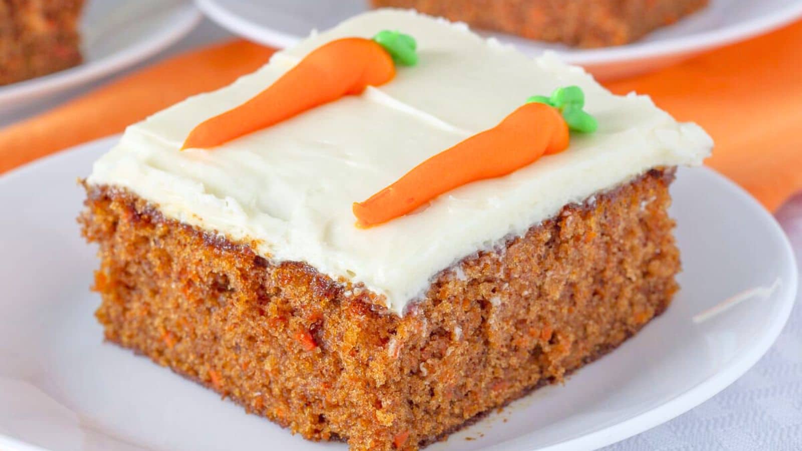 Slice of carrot cake on a white plate.