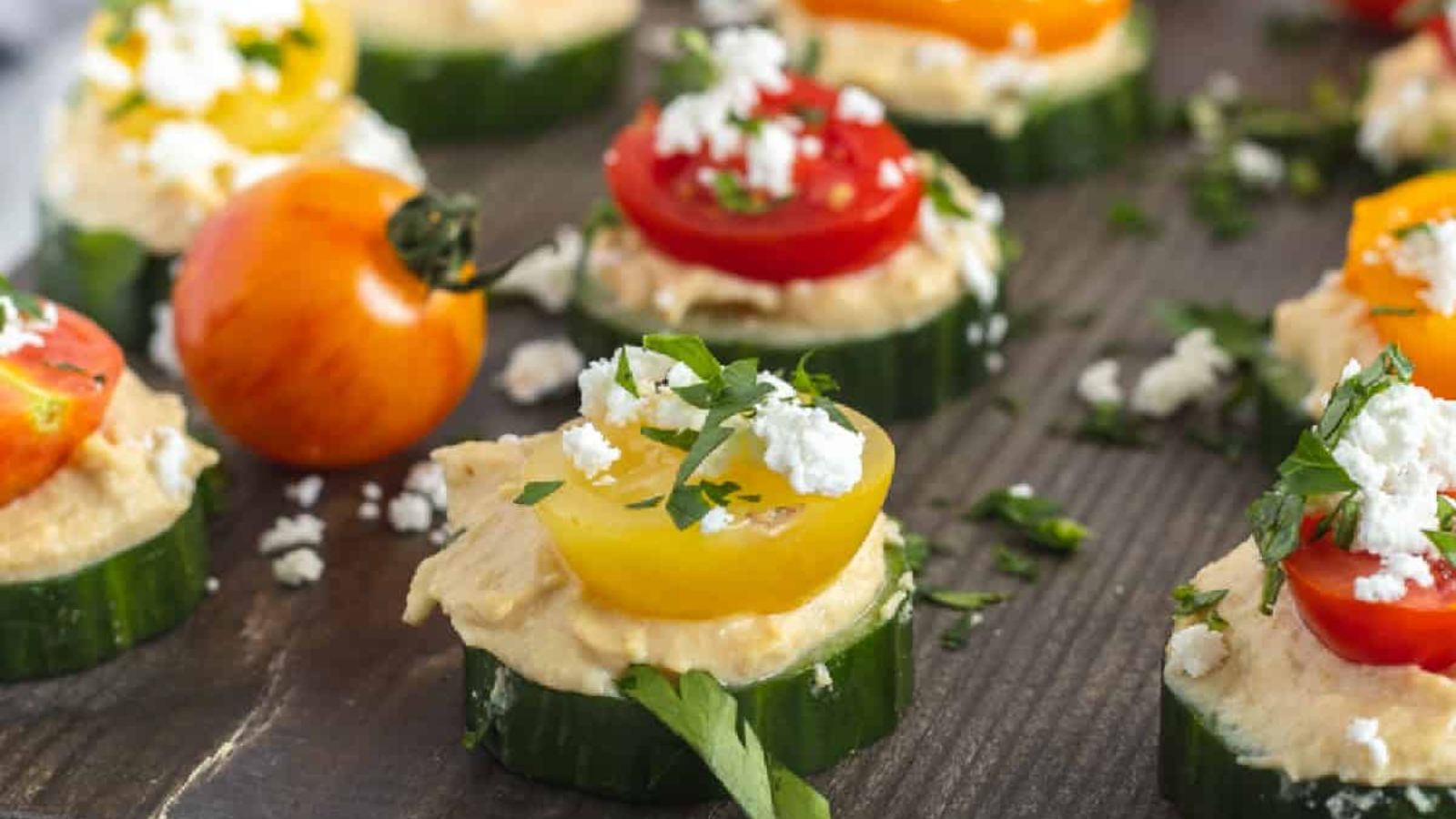 Cucumber hummus bites on a chopping board.