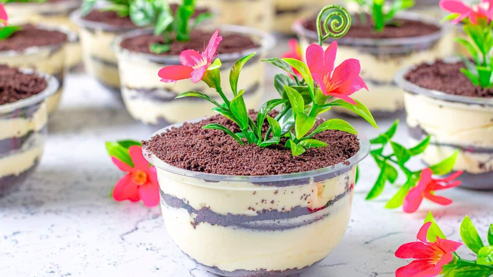 Layered dessert in clear bowls with small flowers.