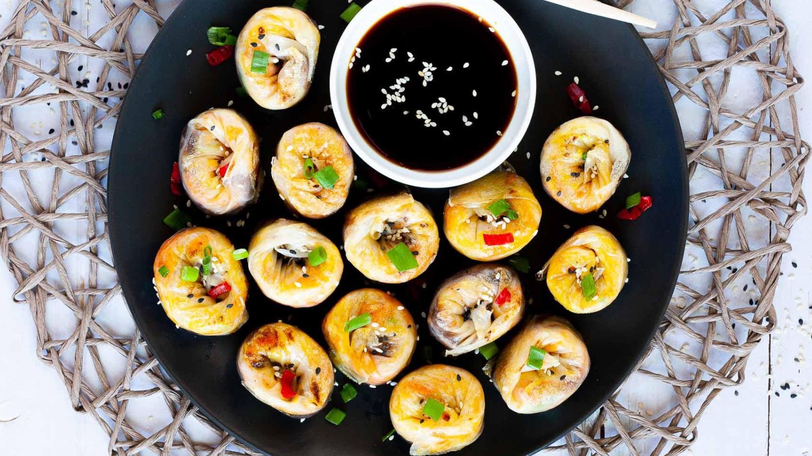 Rice paper dumplings on a plate with dip on the side.