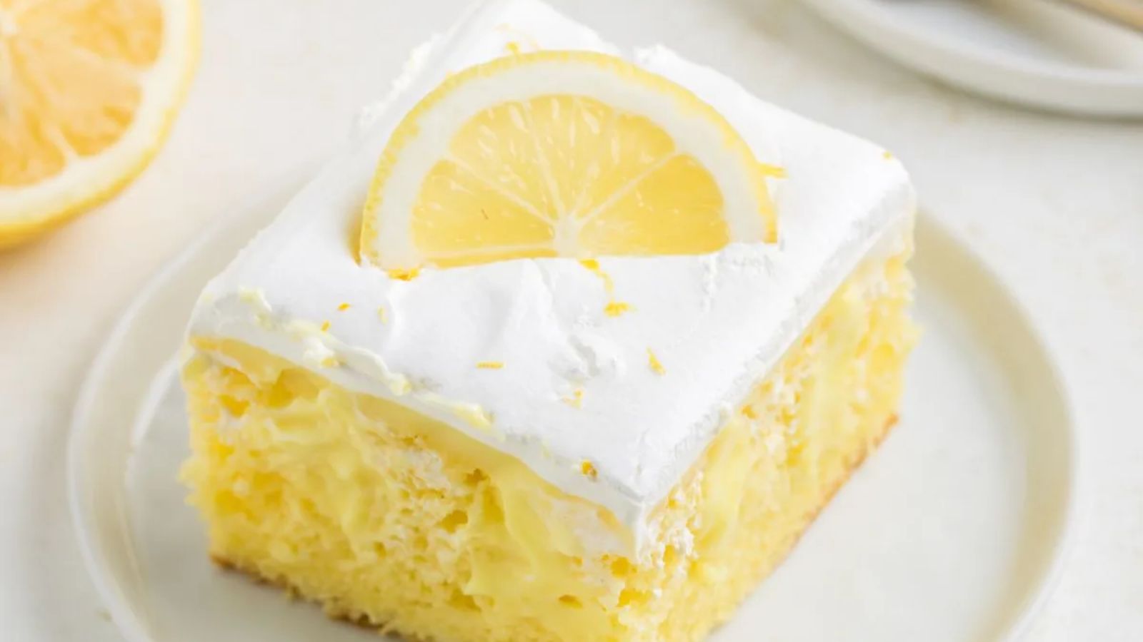A slice of lemon pudding poke cake.