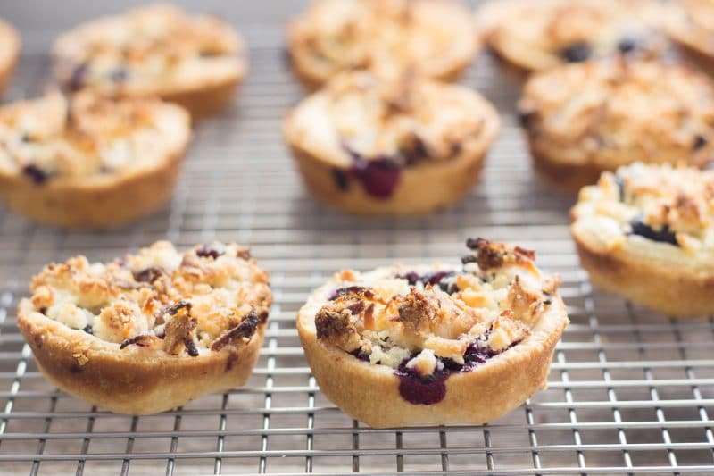 Mini blueberry pies on a cooling rack.