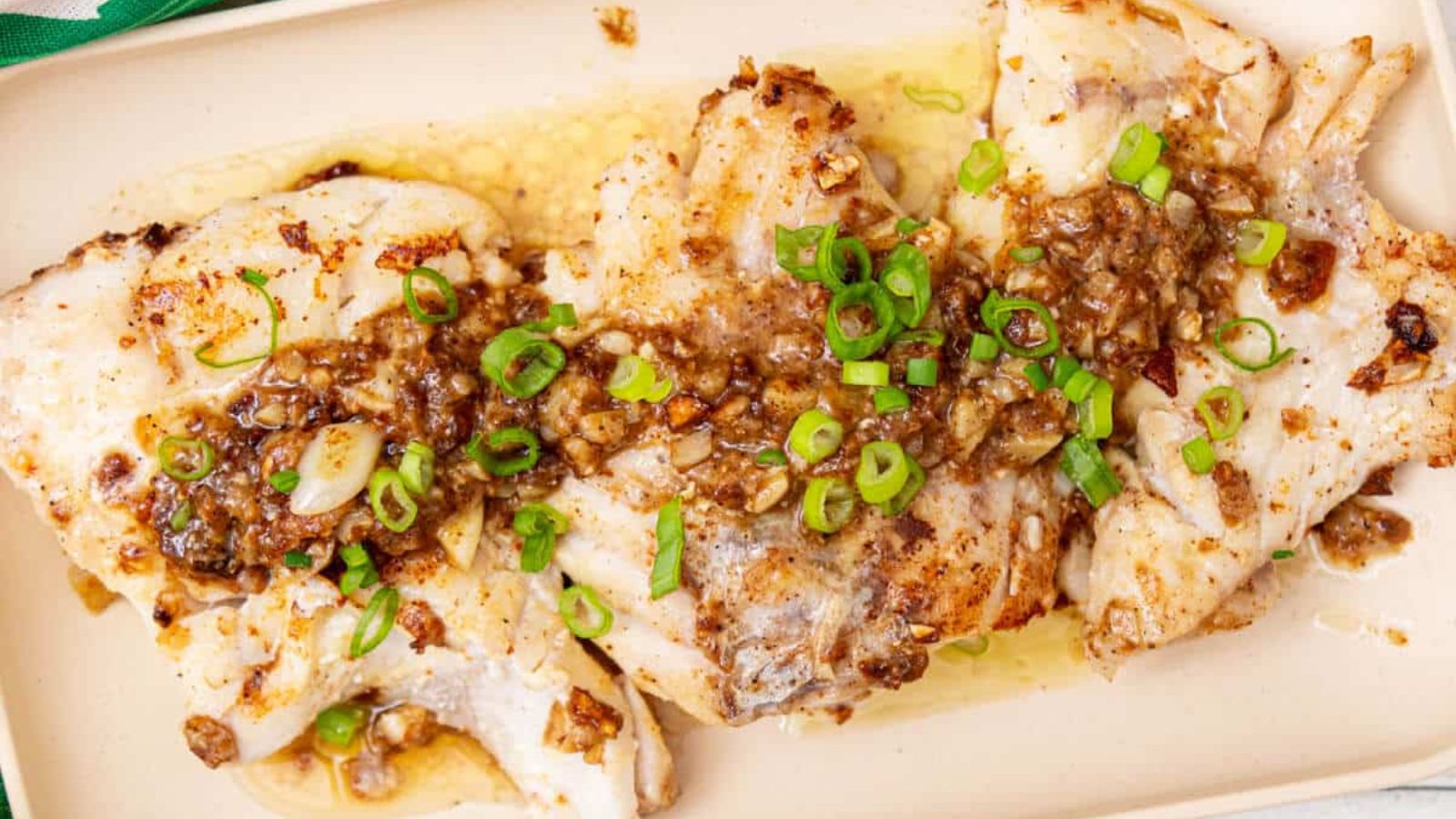 Fried rockfish with onion leaks on top.