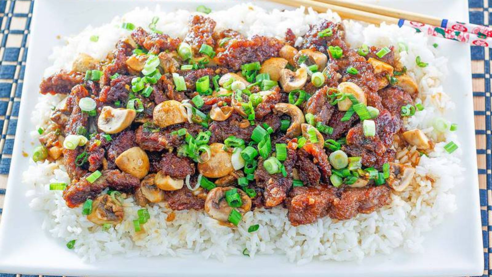 Mongolian beef with onion leaks on top.
