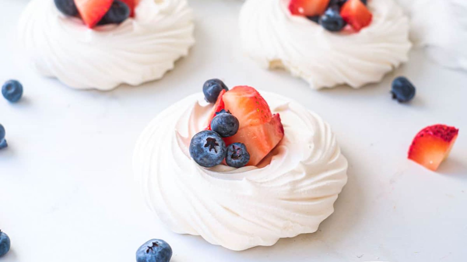 Mini pavlovas with berries on top.