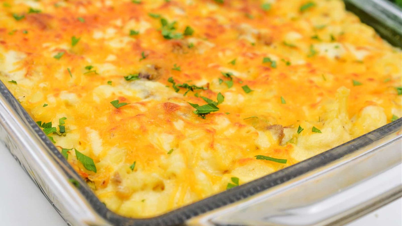 Short rib mac and cheese on a glass tray.