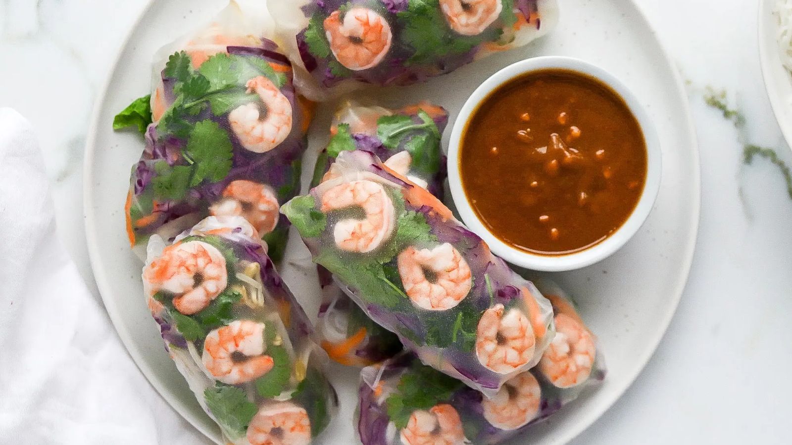 Shrimp rice paper on a plate with dip on the side.