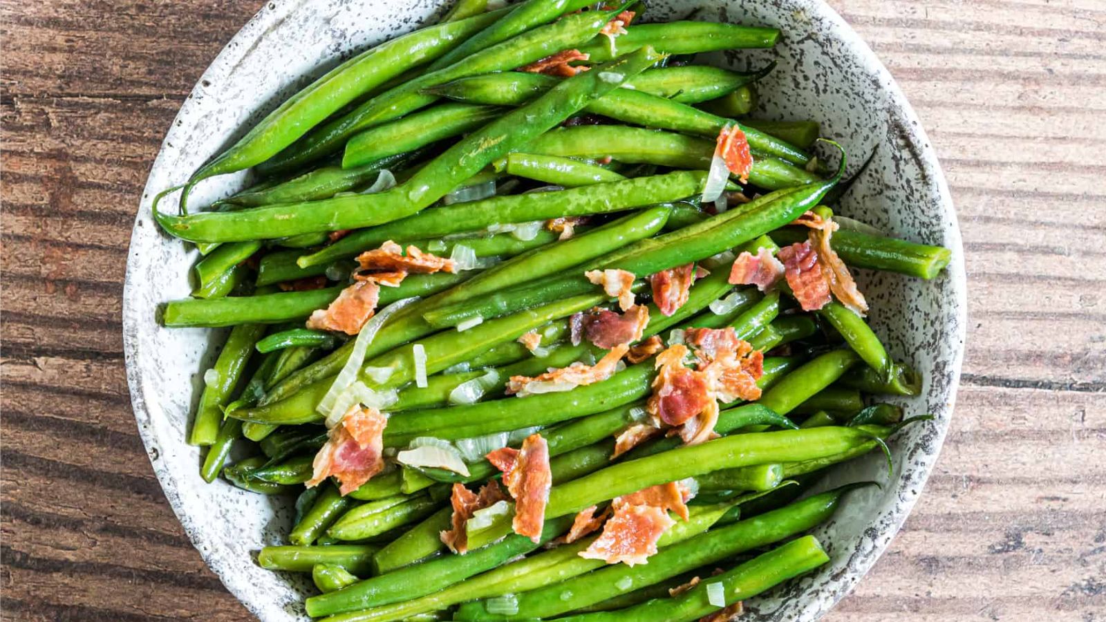 Green beans with bacon bits on top.