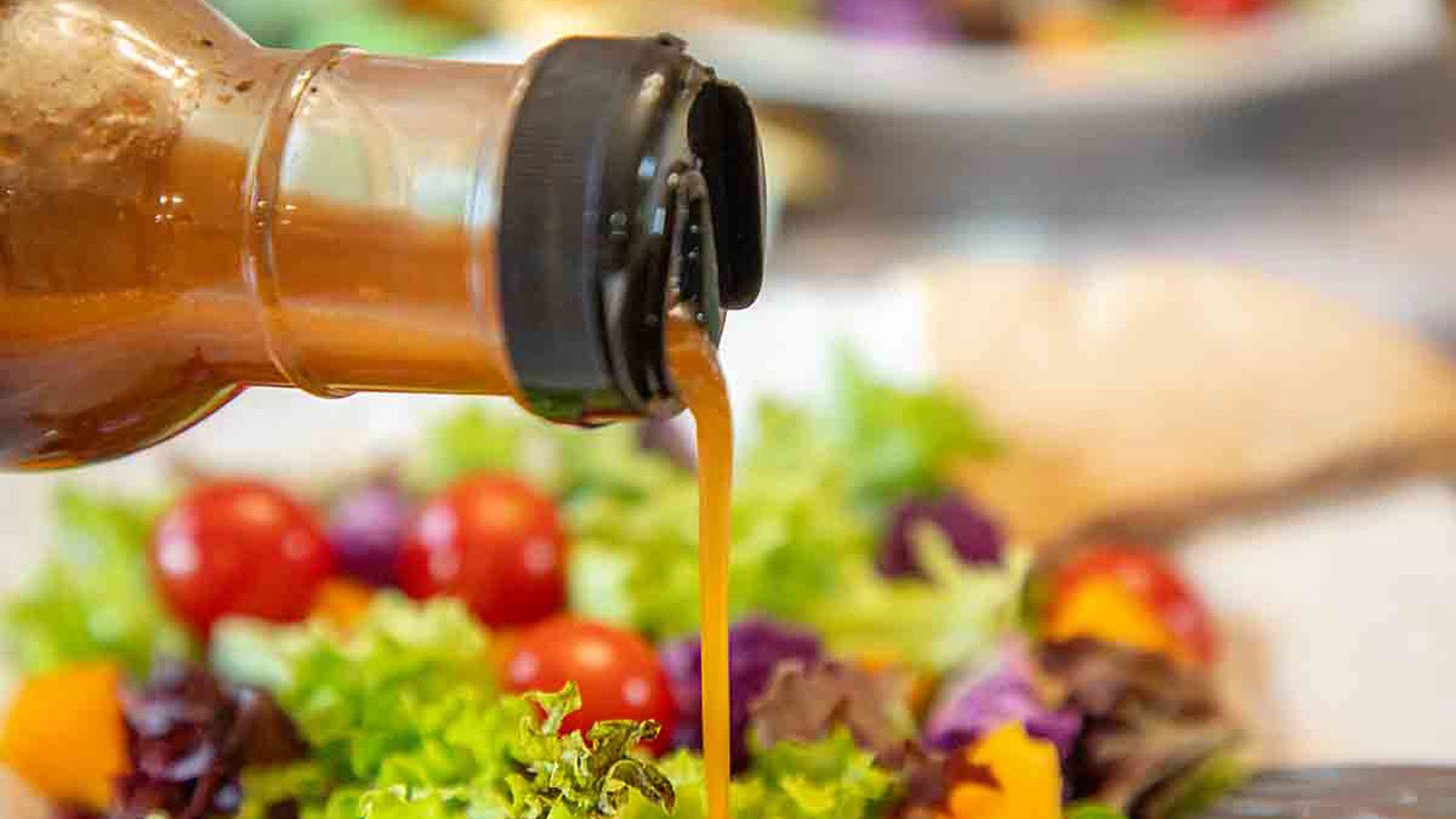 Dressing pouring onto a salad.