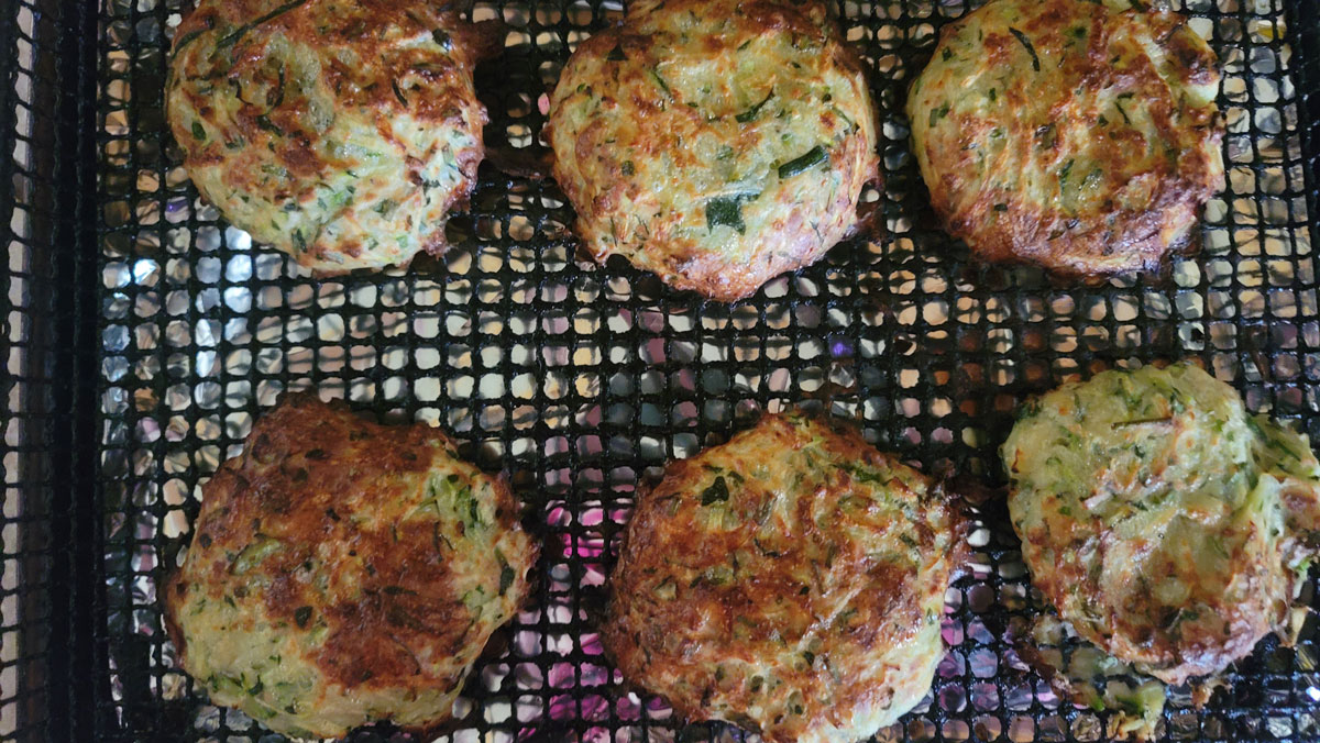 Browned fritters on the air fryer basket.