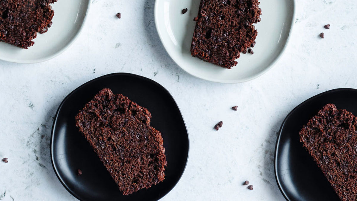 Slices of dark chocolate bread on white and black plates.