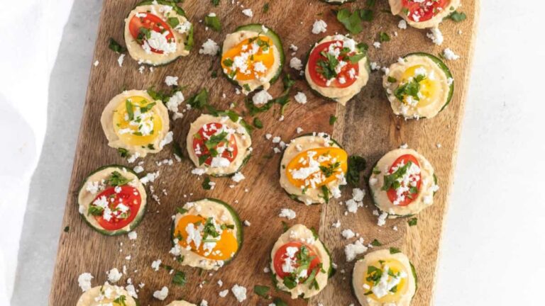 Cucumber hummus bites on a chopping board.