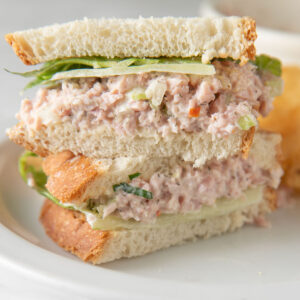 Two halves of a ham sandwich stacked on top of each other.