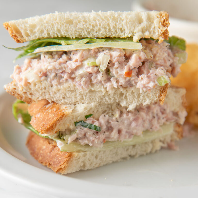 Two halves of a ham sandwich stacked on top of each other.