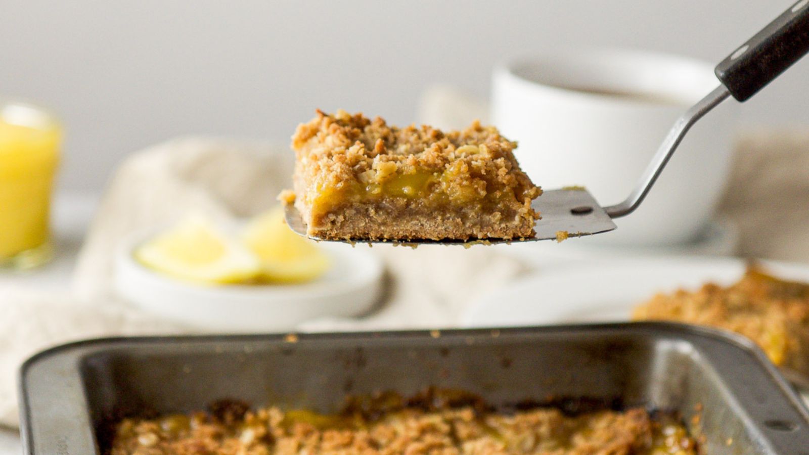 Spatula holding up a lemon bar.