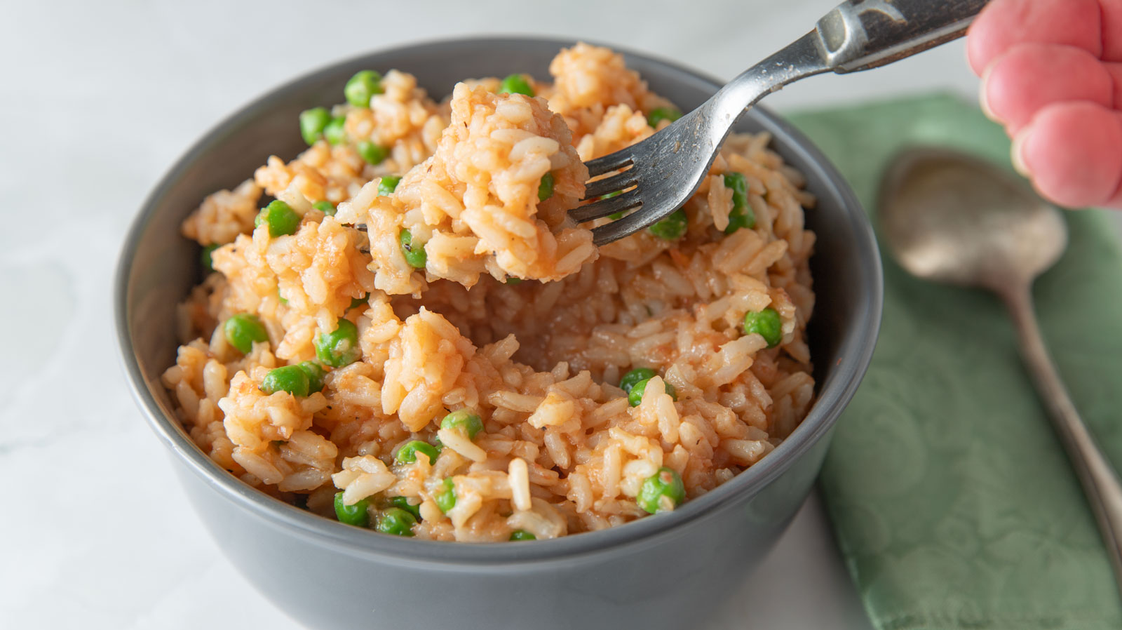 Antique fork scooping rice out of a bowl.