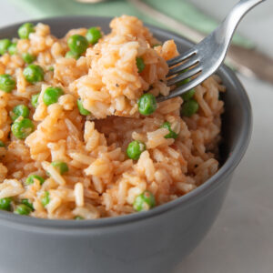 Fork scooping out rice from a bowl.