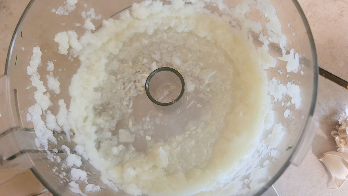 Onion and garlic puréed in a food processor bowl.