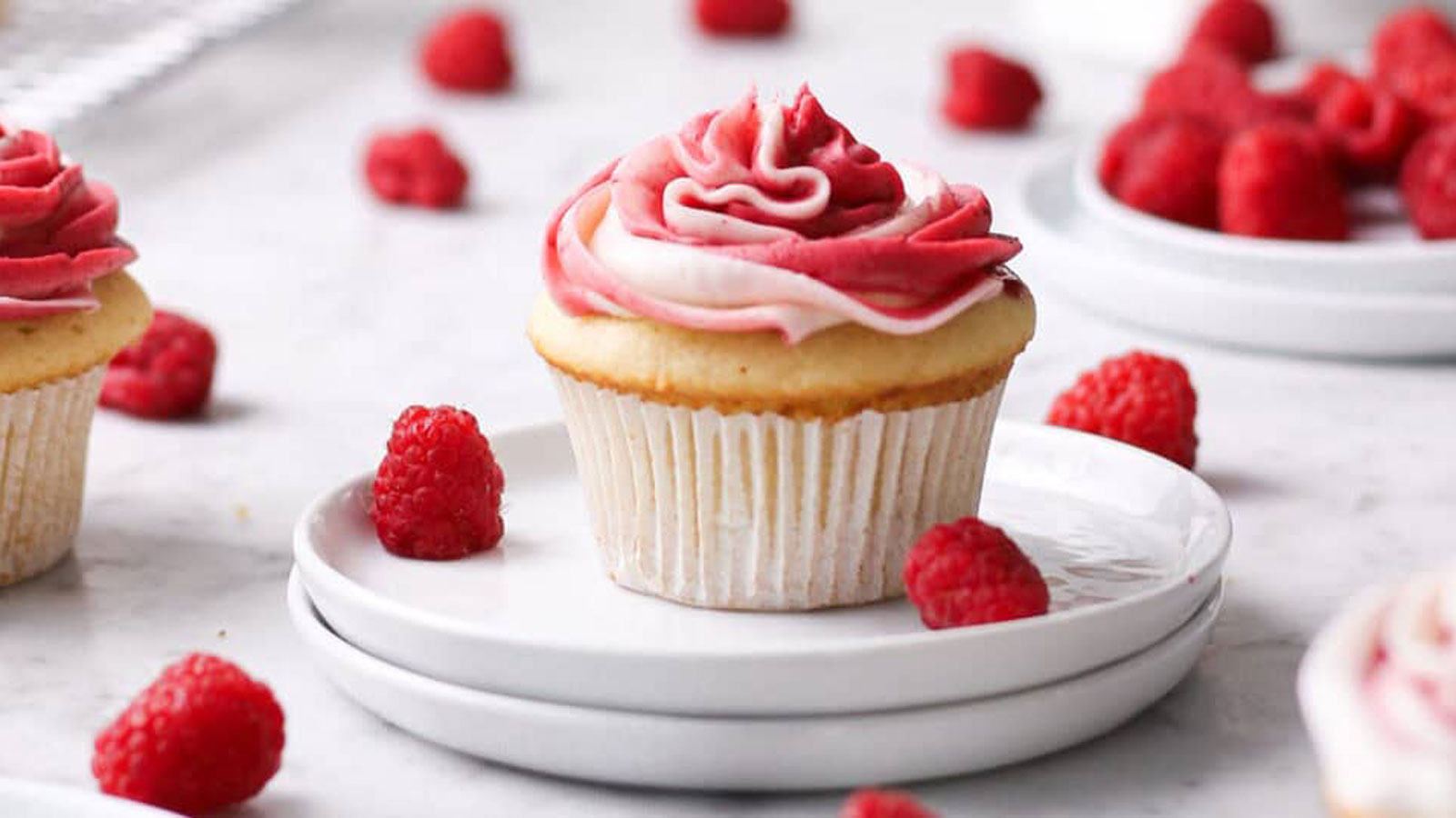 Cupcake with raspberry frosting and topped with a fresh raspberry.