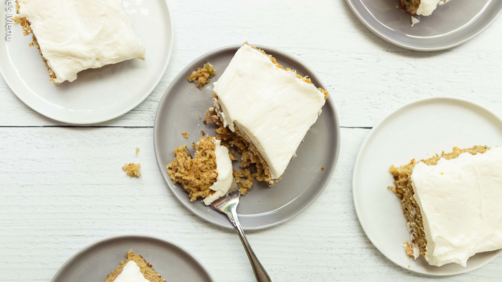 Gray and white plates with pieces of zucchini cake.