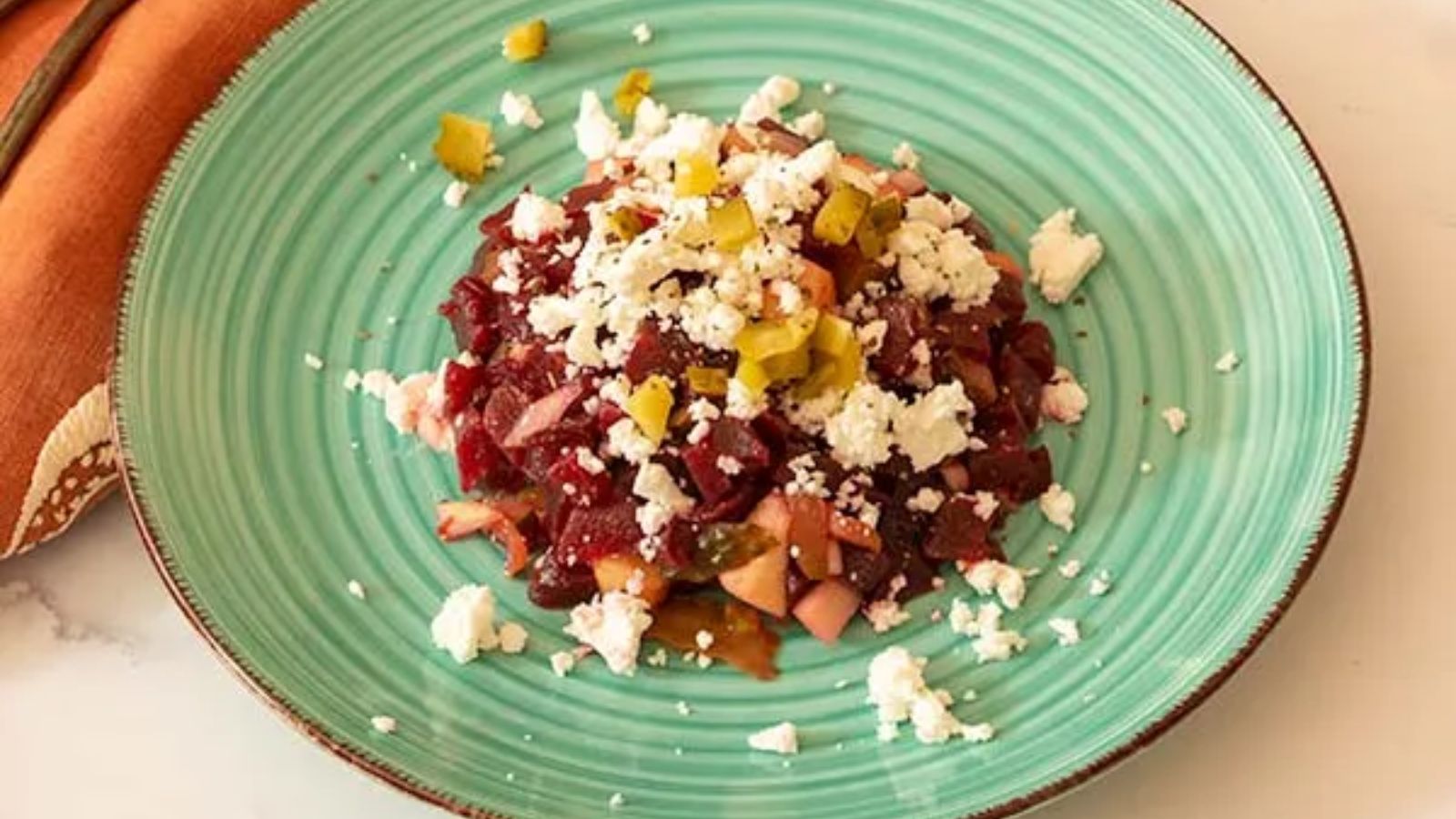 Beet tartare with apple and feta on a plate.