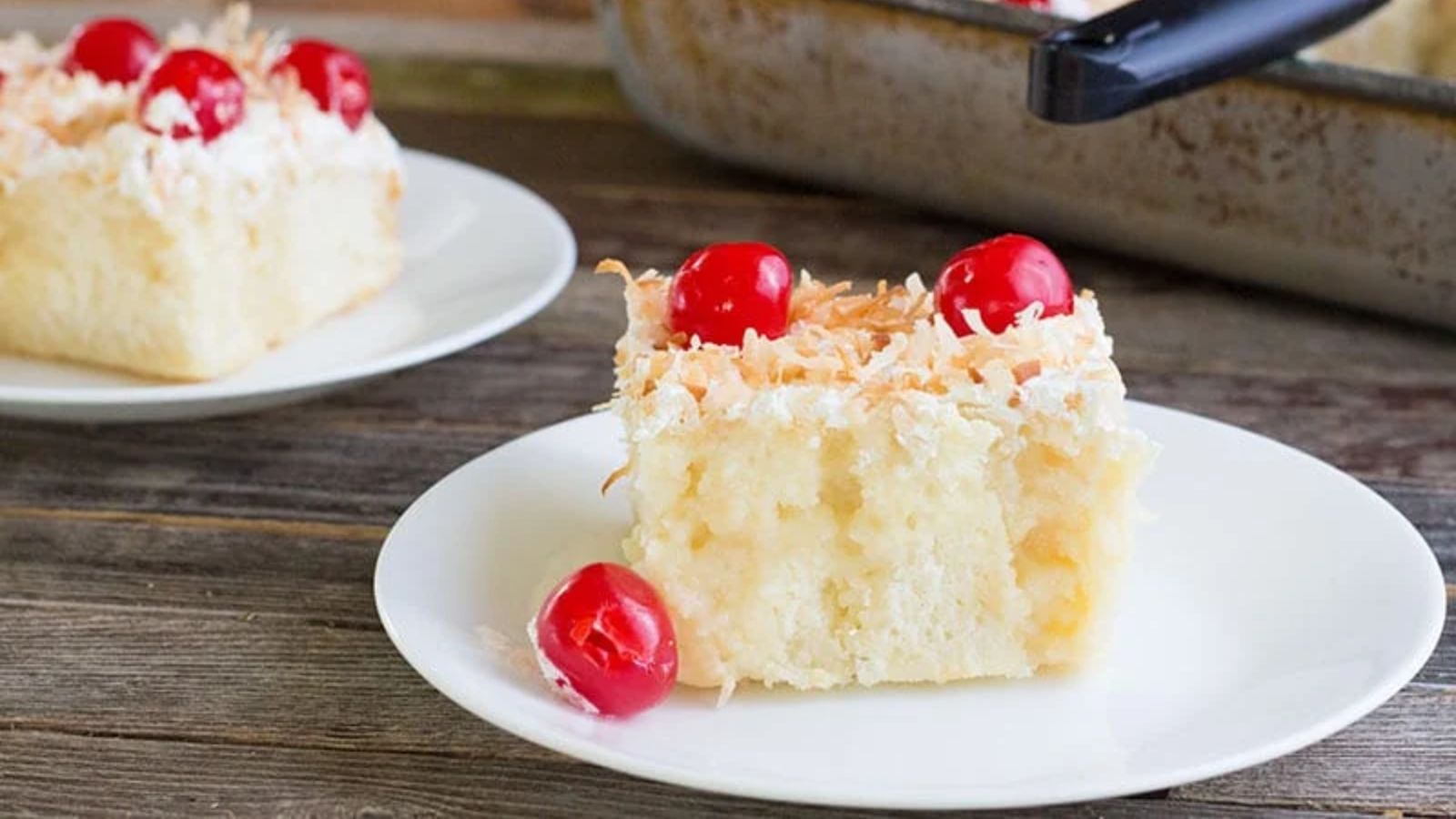 Poke cake with cherries on top.