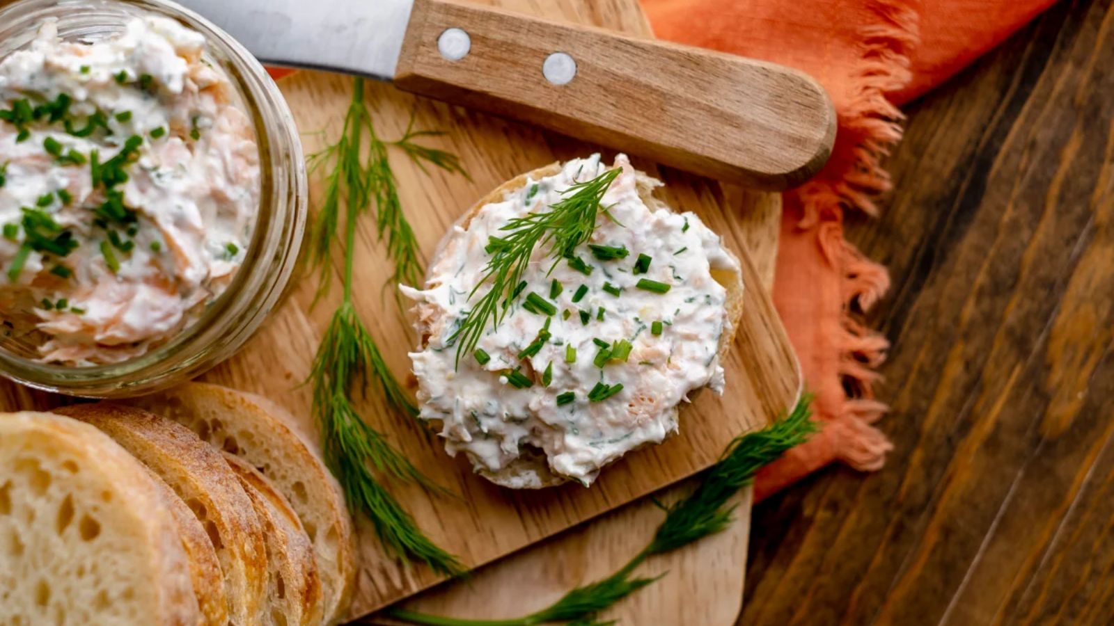 Smoked trout dip with lemon dill on a wooden board.