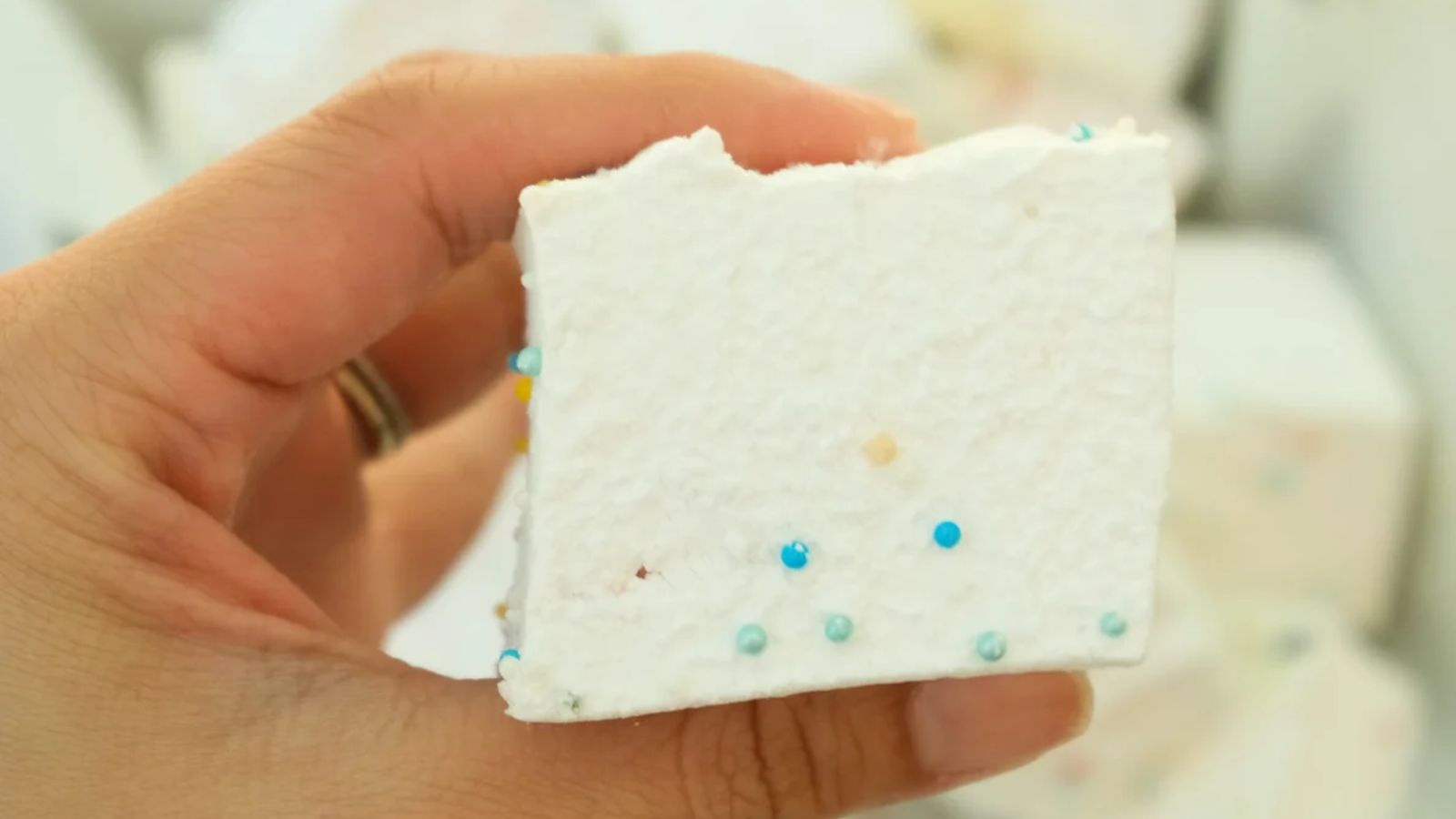 A hand holding a funfetti marshmallow.