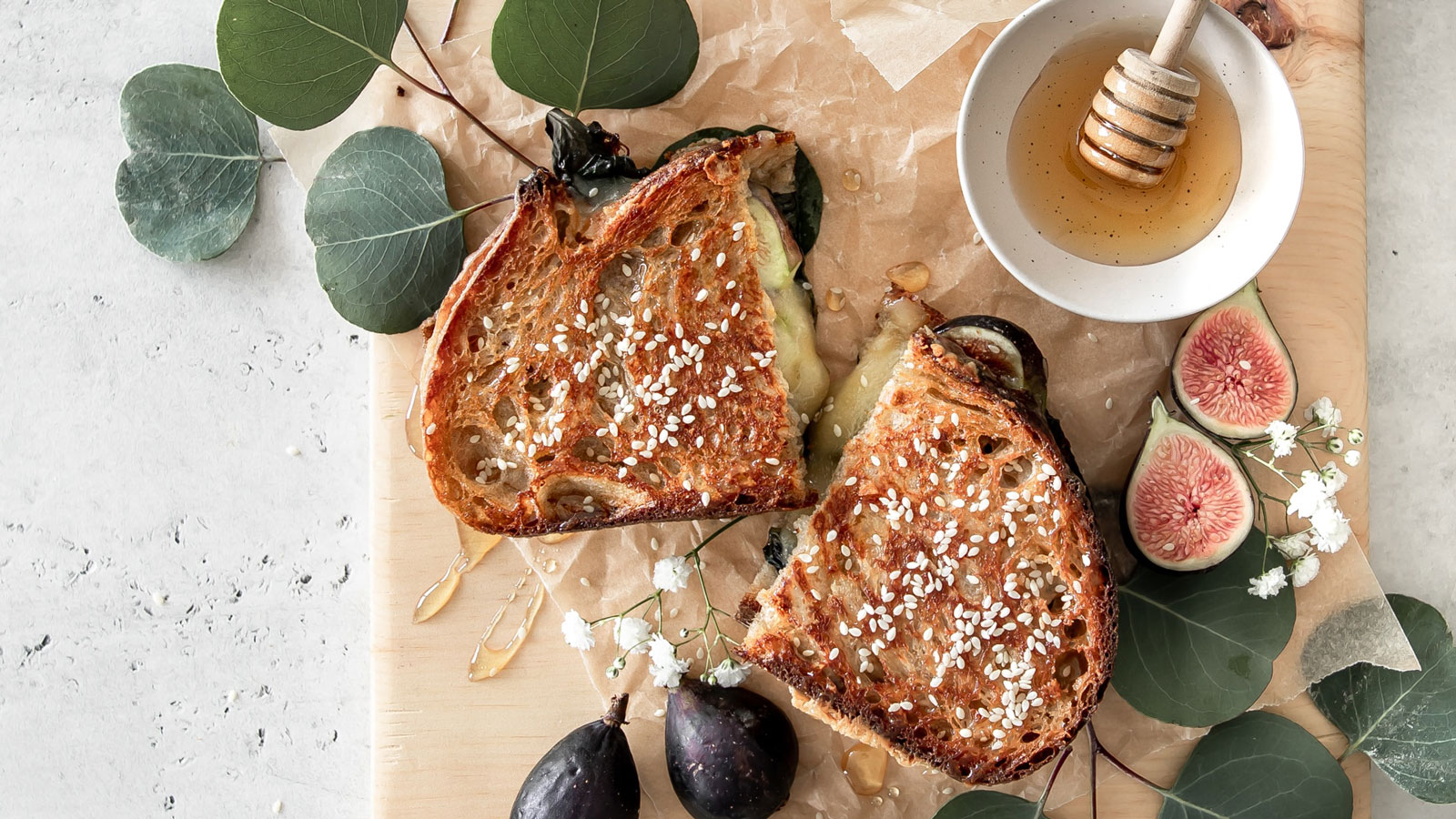 Grilled cheese sandwich on a wooden board with figs.