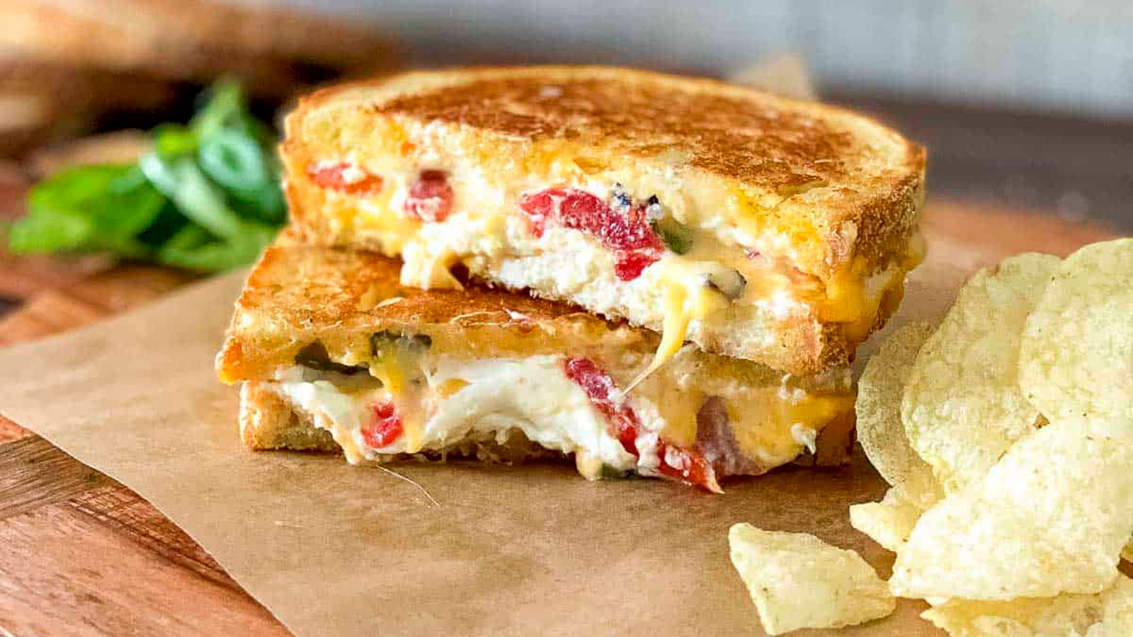 Grilled cheese sandwich cut in half on a wooden board.