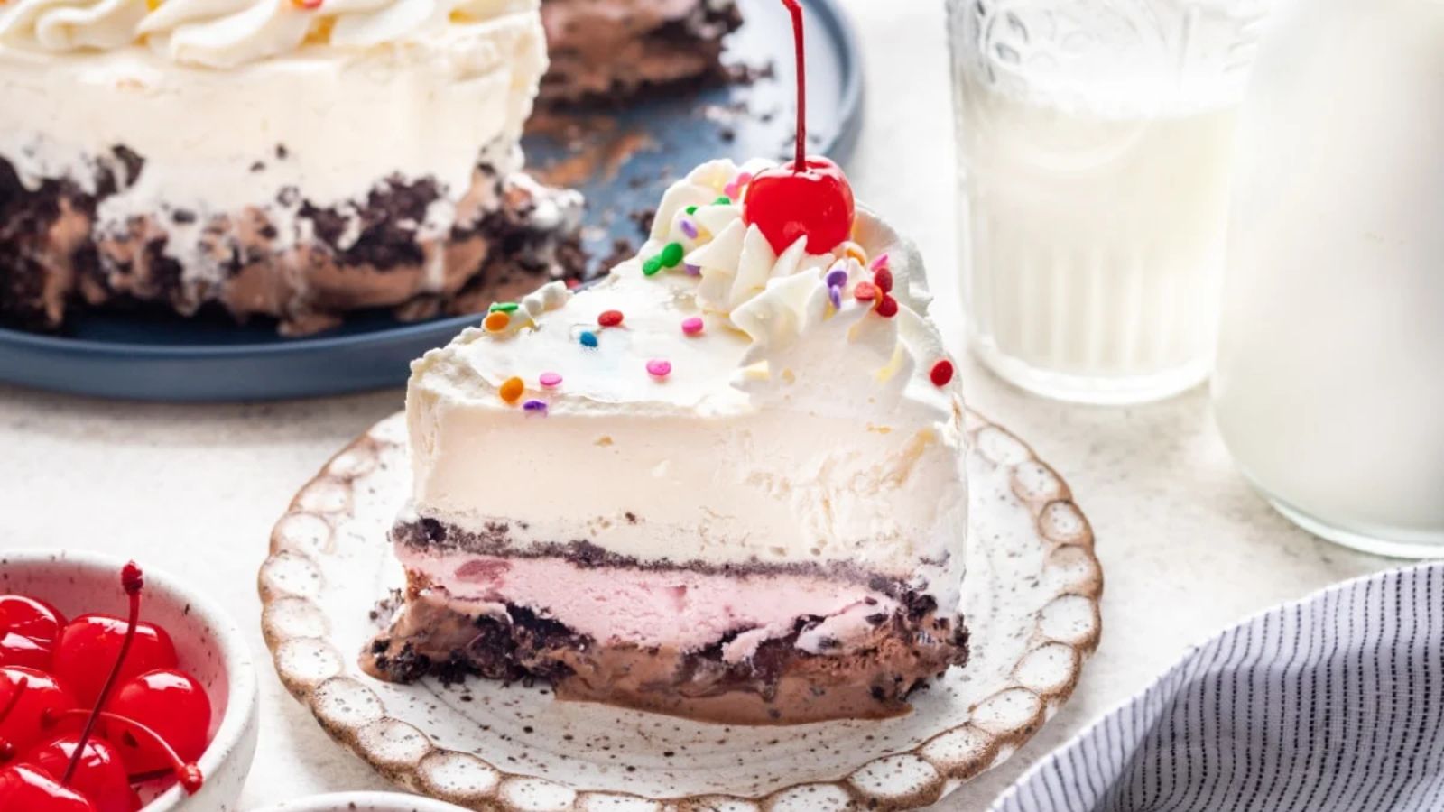 A slice of cake with cherry on top.