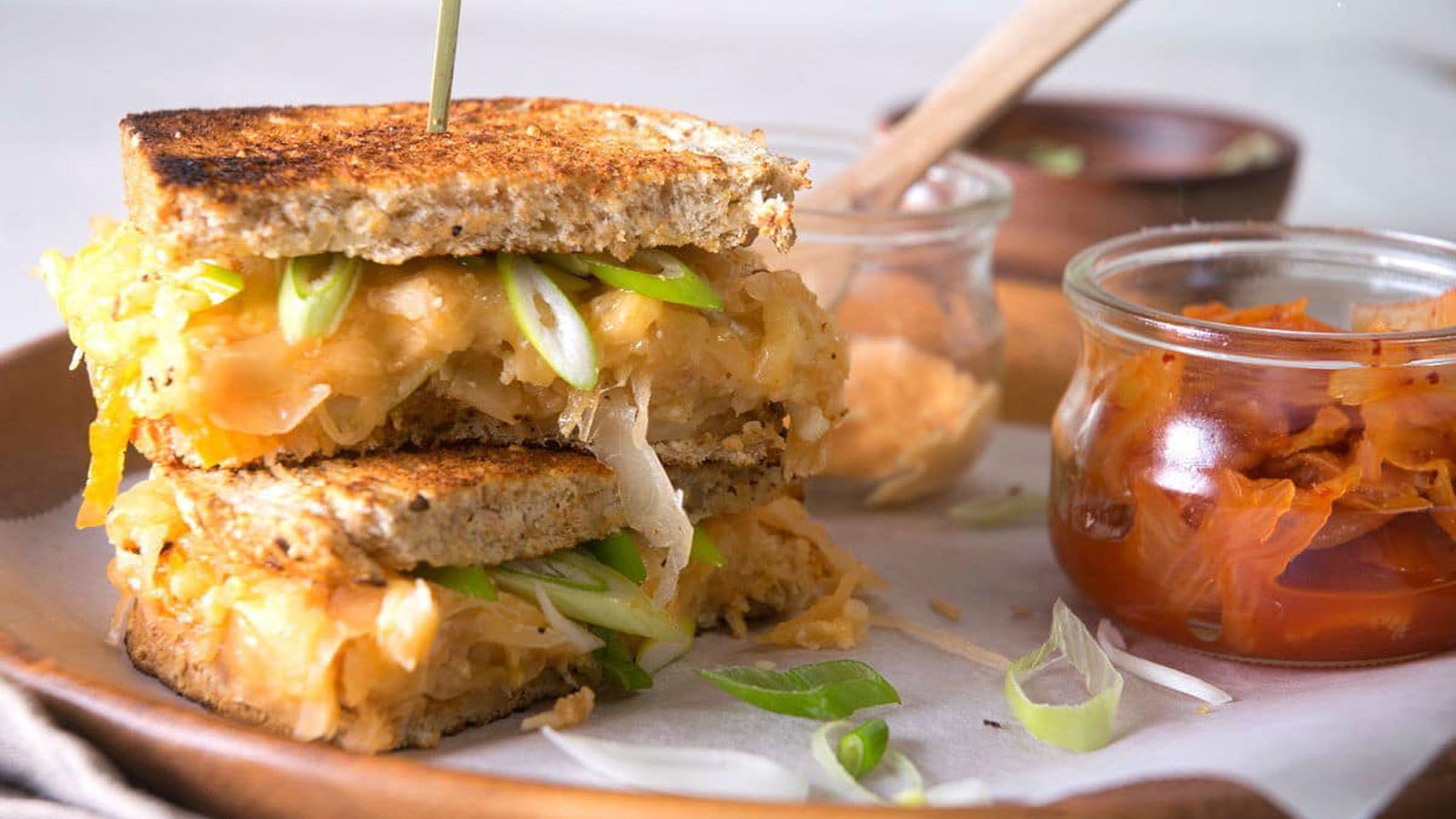 Stacked grilled cheese with kimchi and sliced green onion.