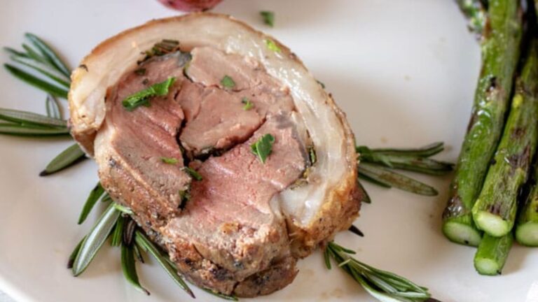 A slice of lamb loin with asparagus on the side.
