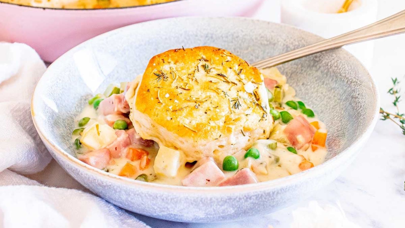 Ham pot pie with biscuit in a bowl.