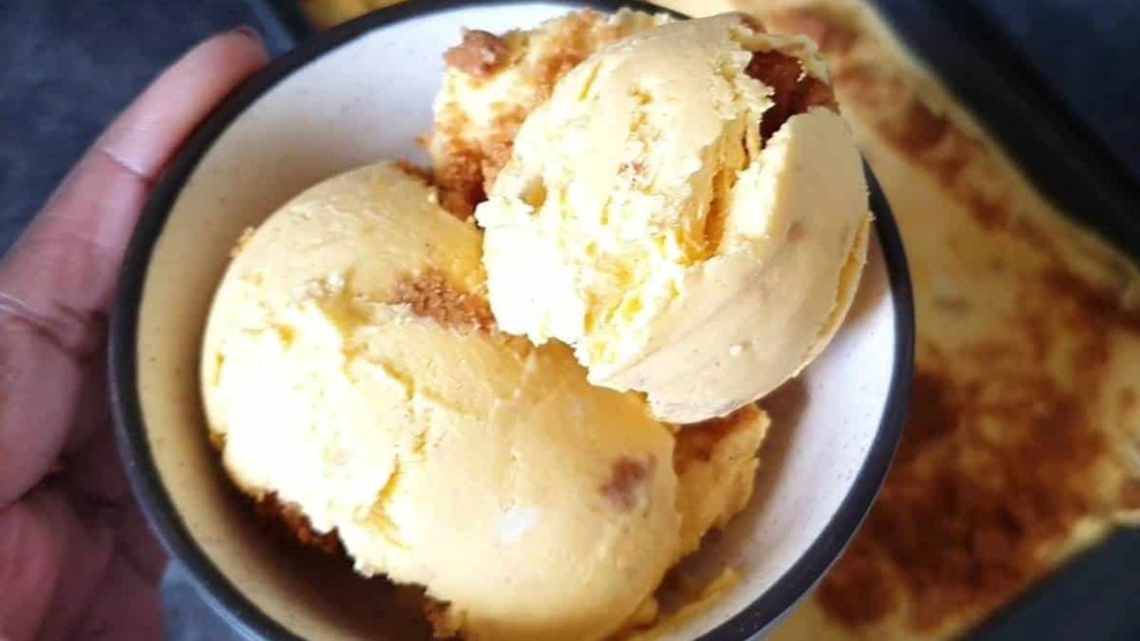 Scoops of mango cheesecake ice cream in a bowl.