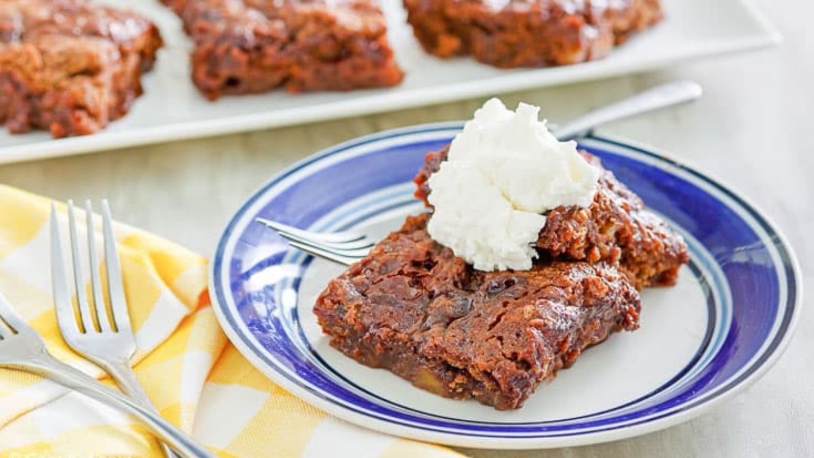 Slice of chocolate cake topped with whipped cream.
