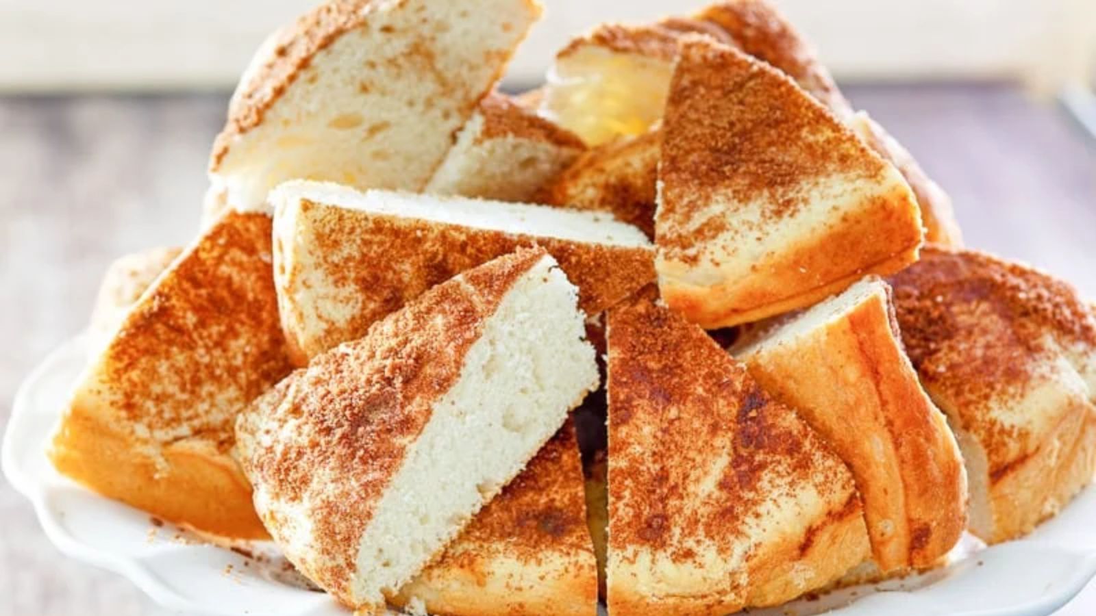 Triangular slices of coffee cake in a pile on a white plate.