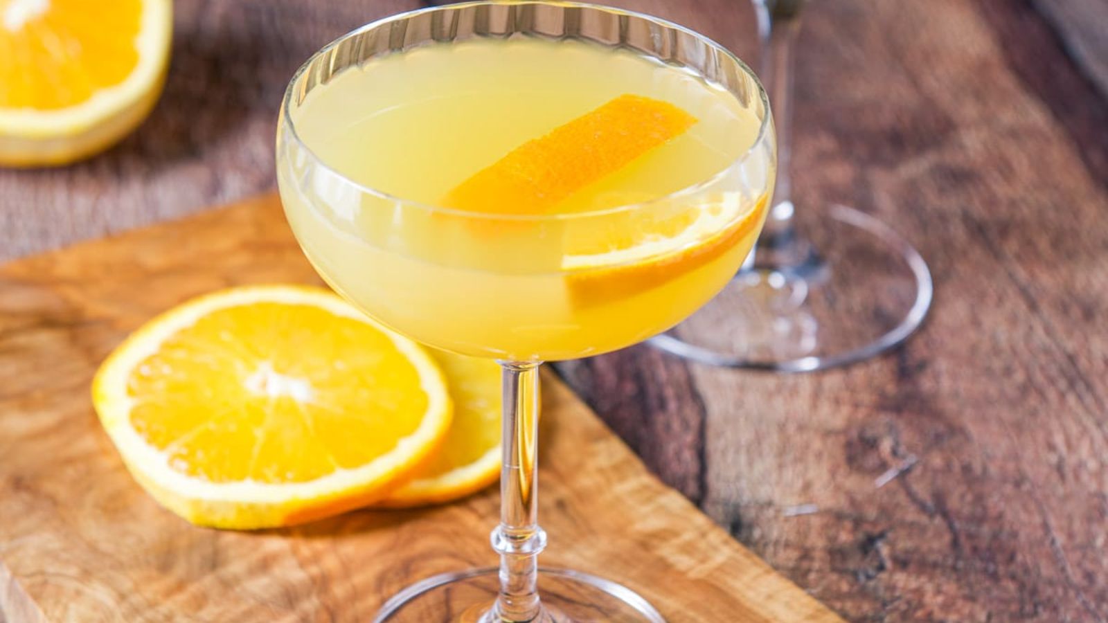 Paradise cocktail in with sliced oranges at the back.