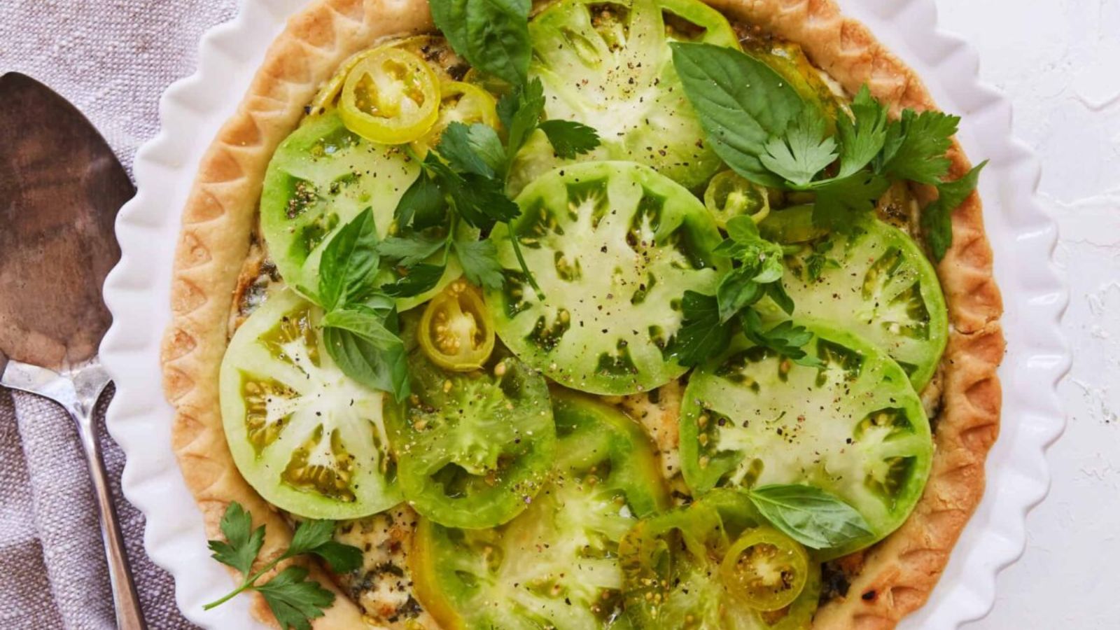 Green tomato pie with fresh tomatoes on top.