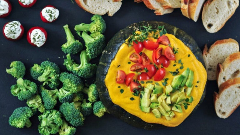 Spicy Chipotle Kabocha dip in the squash shell garnished with chopped vegetables.