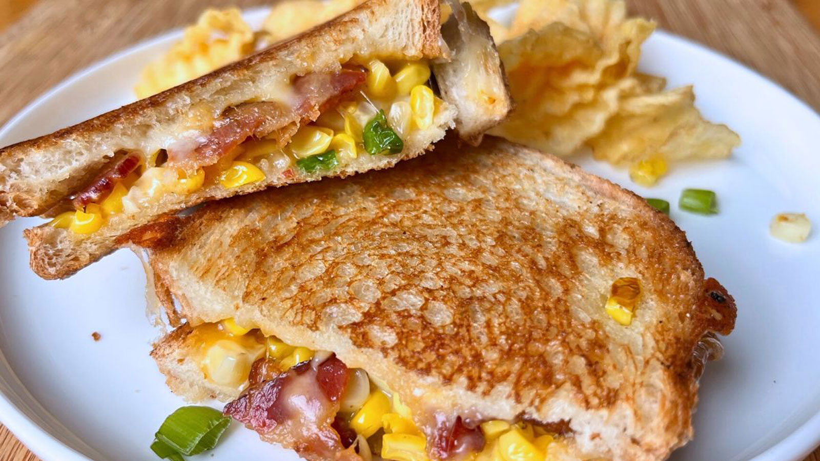 Halved grilled cheese with kernels of ham and chunks of bacon.